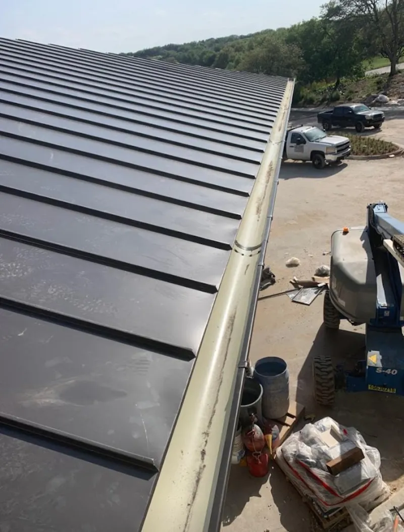 Standing seam panel and gutter detail on a metal roofing jobsite in Olney